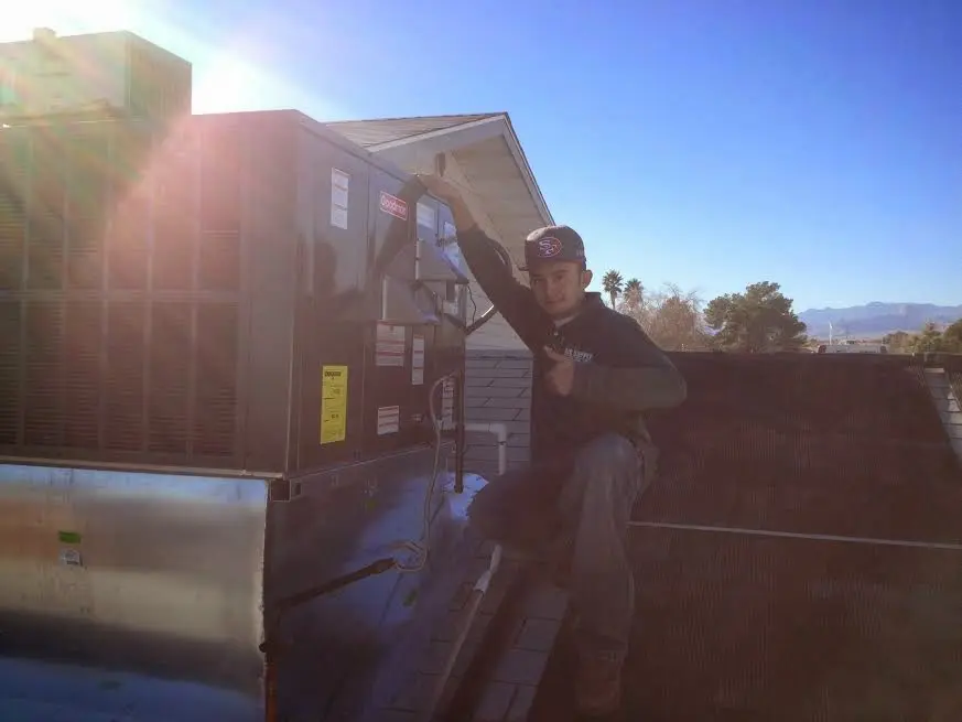 HVAC technician performing Heat Pump Repair on a rooftop unit in Mount Vernon